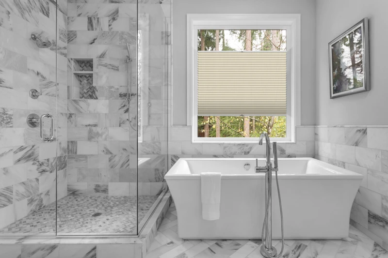 Bathroom with bathtub and shower in new luxury home with all gla