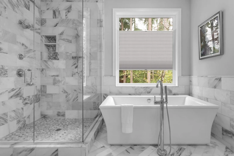 Bathroom with bathtub and shower in new luxury home with all gla