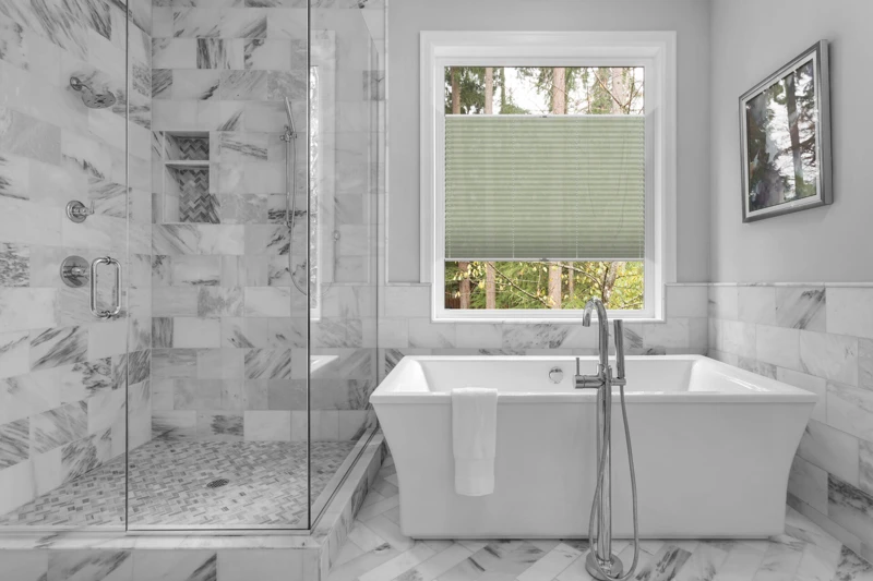 Bathroom with bathtub and shower in new luxury home with all gla