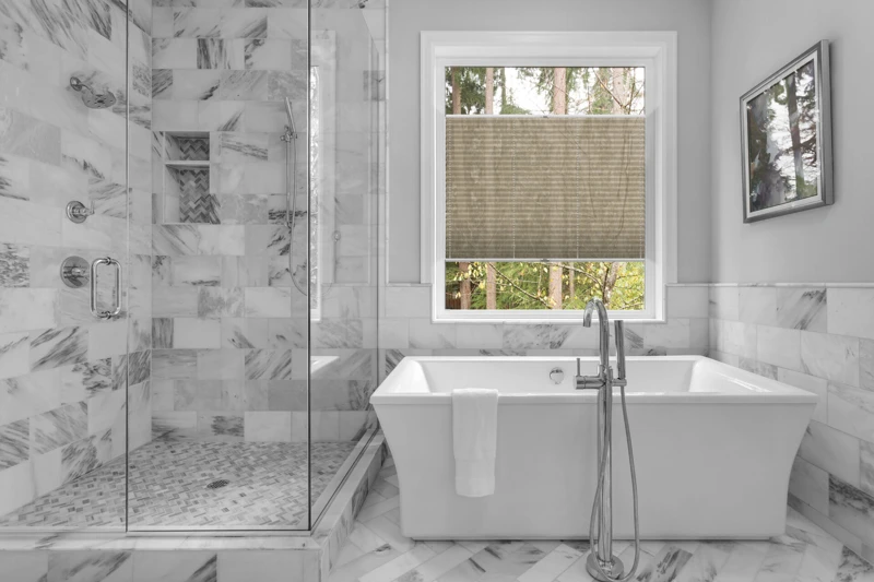 Bathroom with bathtub and shower in new luxury home with all gla